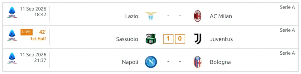 A slim match list where one row is in play - in place of its kickoff time it shows an orange LIVE badge, a running minute and the text 1st Half, with an orange 1-0 score, while the rows above and below still show their kickoff date and time and a dash for the score